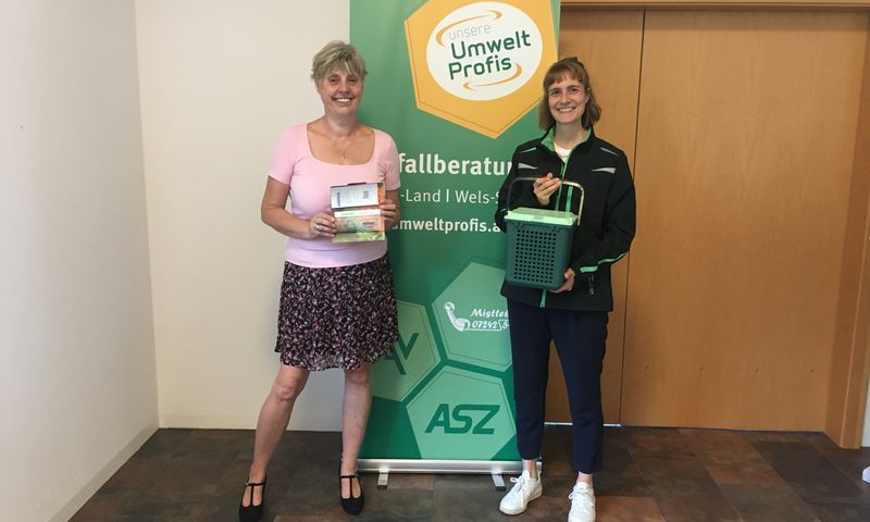 Gewinnerin Petra Kaiblinger steht mit Gutschein in der Hand neben Abfallberaterin Stephanie Wagner.