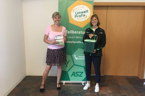 Gewinnerin Petra Kaiblinger steht mit Gutschein in der Hand neben Abfallberaterin Stephanie Wagner.