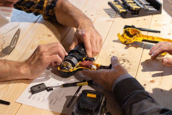 Hände die ein Elektrogerät repaieren